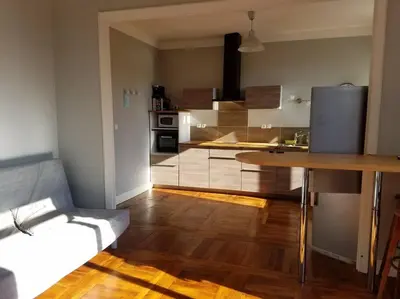 a kitchen with a wooden floor and a table in it at T2 Gautier proche Cité Médiévale parking privé in Carcassonne
