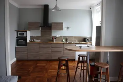 a kitchen with a table and some stools in it at T2 Gautier proche Cité Médiévale parking privé in Carcassonne