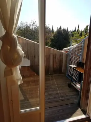 a sliding glass door with a view of a deck at T2 Gautier proche Cité Médiévale parking privé in Carcassonne