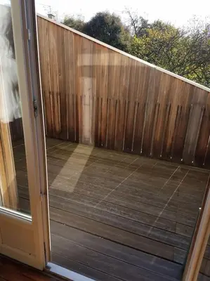 an open door to a deck with a wooden fence at T2 Gautier proche Cité Médiévale parking privé in Carcassonne