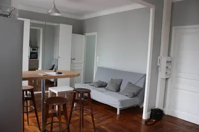 a living room with a couch and a table with stools at T2 Gautier proche Cité Médiévale parking privé in Carcassonne