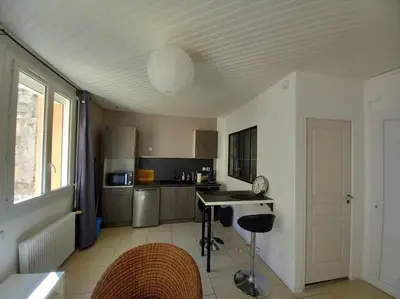 a kitchen with a table and chairs in it at Appart Distillerie in Narbonne