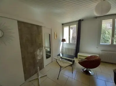 a living room with a chair and a desk at Appart Distillerie in Narbonne