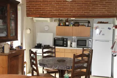 a small kitchen with a table and a refrigerator at Chez Didier 1 in Saint-Michel-de-Lanès