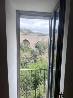 a window in a room with a view of a bridge at Nichoir des gorges in Montolieu