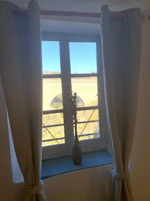 a window with curtains in a room with a view at Nichoir des gorges in Montolieu