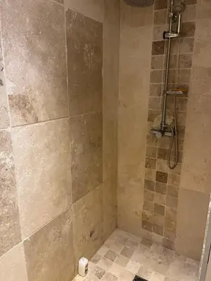 a bathroom with a shower with a tiled floor at Nichoir des gorges in Montolieu