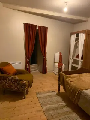 a bedroom with a bed and a chair and a window at Nichoir des gorges in Montolieu