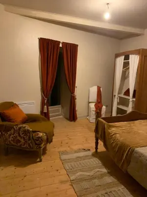 a bedroom with a bed and a chair and a window at Nichoir des gorges in Montolieu