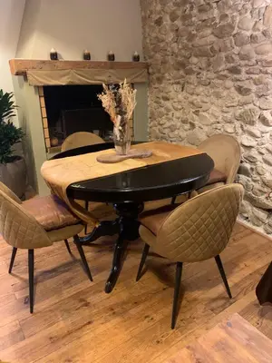 a dining room table with chairs and a fireplace at Nichoir des gorges in Montolieu
