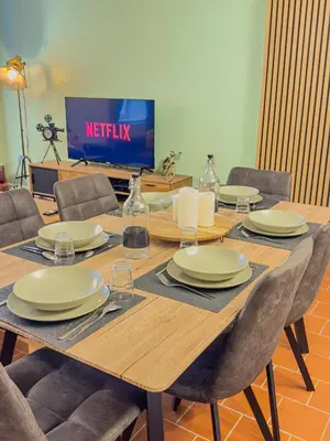 a table with chairs and a television in a room at La Cité Voltaire in Carcassonne