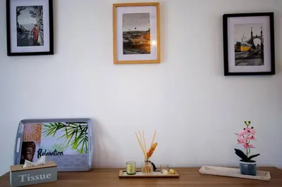 a table with a clock and pictures on a wall at La casa du lac vue imprenable in Homps