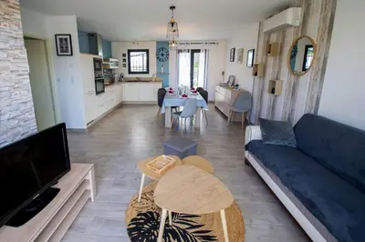 a living room with a blue couch and a table at La casa du lac vue imprenable in Homps