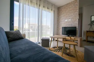 a living room with a couch and a television at La casa du lac vue imprenable in Homps
