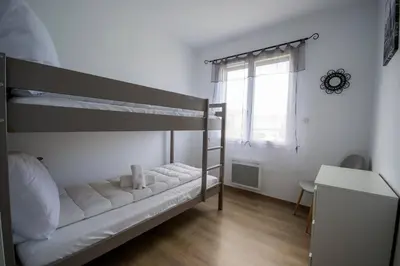 a bedroom with a bunk bed with a desk and a window at La casa du lac vue imprenable in Homps