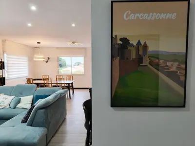 a living room with a couch and a painting on the wall at Appartement Familial proche de Carcassonne in Villemoustaussou