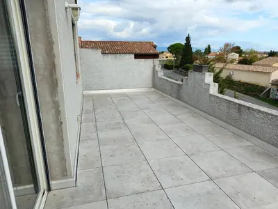 an empty balcony with a view of a house at Appartement Familial proche de Carcassonne in Villemoustaussou