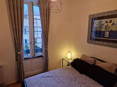 a bedroom with a bed and a window at Appartement cosy hypercentre in Narbonne