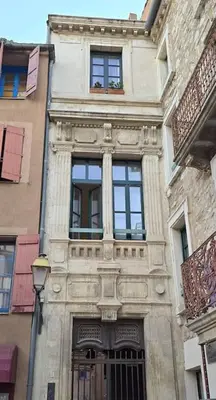 a tall building with windows on a city street at Appartement cosy hypercentre in Narbonne