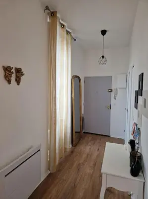 a room with a hallway with a table and a mirror at Appartement cosy hypercentre in Narbonne