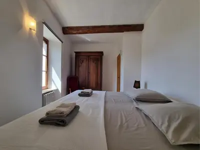 a bedroom with a large white bed with towels on it at La Roche 6 in Aigues-Vives