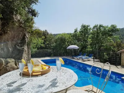 a table with chairs next to a swimming pool at La Roche 6 in Aigues-Vives