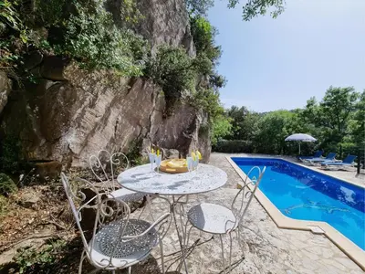 a table and chairs next to a swimming pool at La Roche 6 in Aigues-Vives