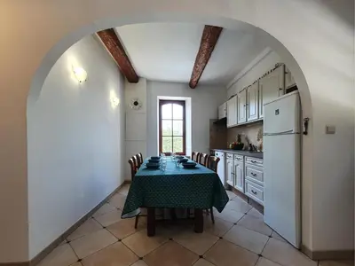 a kitchen with a table and a refrigerator at La Roche 6 in Aigues-Vives