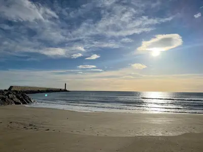 a sandy beach with the ocean and a pier at Palma Studio bis 4 pers - 100m plage in Port-la-Nouvelle