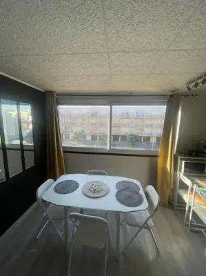 a white table and chairs in a room with a window at Palma Studio bis 4 pers - 100m plage in Port-la-Nouvelle