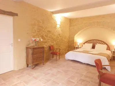 a bedroom with a bed and a table and chairs at Domaine des Périès - Chambres d'hôtes in Saint-Martin-Lalande
