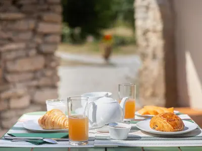 a table with plates of food and glasses of orange juice at Domaine des Périès - Chambres d'hôtes in Saint-Martin-Lalande