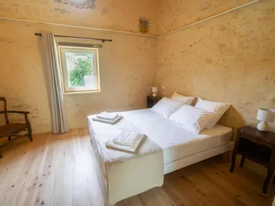a bedroom with a white bed and a window at Domaine des Périès - Chambres d'hôtes in Saint-Martin-Lalande