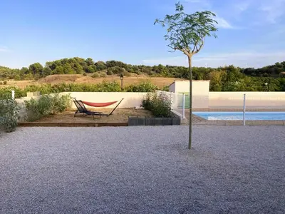 a hammock and a tree next to a pool at Lily in Escales