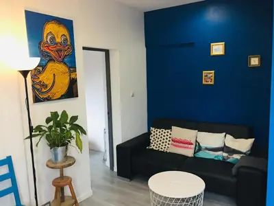 a living room with a black couch and a blue wall at Anna's gîte in Lagrasse
