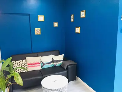 a blue living room with a black couch with pillows at Anna's gîte in Lagrasse