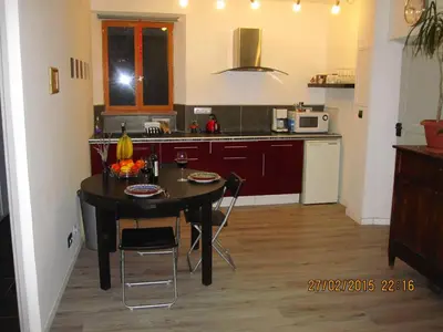 a kitchen with a table with chairs and a table and a kitchen with at Anna's gîte in Lagrasse