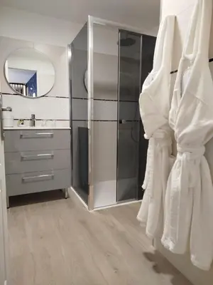 a bathroom with a shower and a sink and a mirror at Love Room Emoi de toi in Sigean
