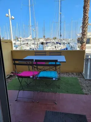 a living room with a couch and a kitchen at Appartement en résidence avec vue et accès au port in Gruissan