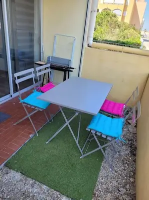 a table and two chairs sitting on a porch at Appartement en résidence avec vue et accès au port in Gruissan
