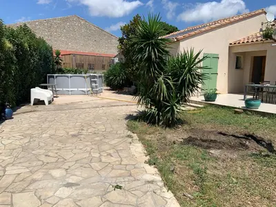 a yard with a stone walkway in front of a house at les amandiers in Salses-le-Chateau