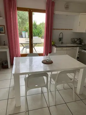 a kitchen with a white table and two chairs at les amandiers in Salses-le-Chateau