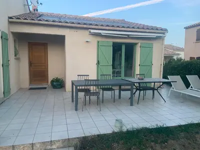 a patio with a table and chairs in front of a house at les amandiers in Salses-le-Chateau