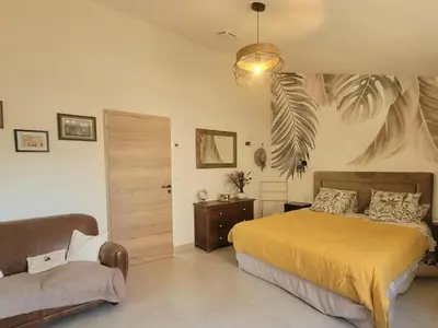 a bedroom with a bed and a couch in it at Les Amandiers in Sallèles-dʼAude