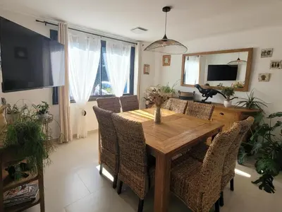 a dining room with a wooden table and chairs at Les Amandiers in Sallèles-dʼAude