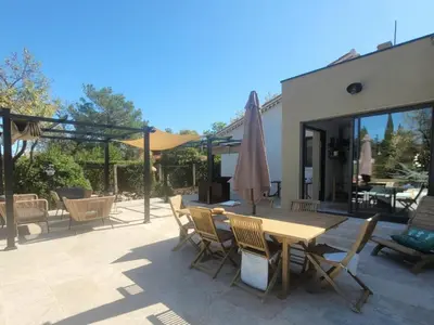 a patio with a wooden table and chairs at Les Amandiers in Sallèles-dʼAude