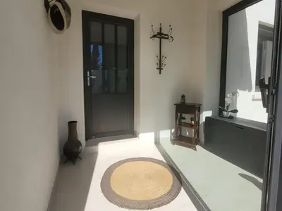 a hallway with a door and a rug on the floor at Les Amandiers in Sallèles-dʼAude