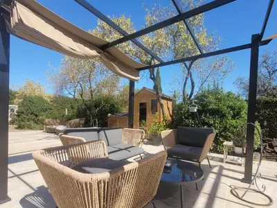 a patio with a couch and chairs and a table at Les Amandiers in Sallèles-dʼAude