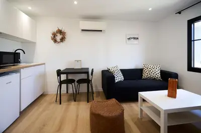 a living room with a couch and a table at La Villa Orange - Proche cité médiévale et centre ville à pied in Carcassonne