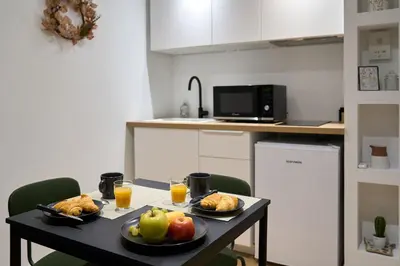 a table with two plates of food and fruit on it at La Villa Orange - Proche cité médiévale et centre ville à pied in Carcassonne